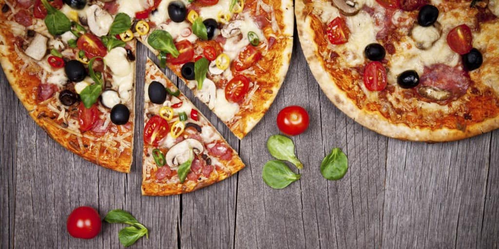 Two pizzas, one with a slice cut out to teach KS2 children fractions.