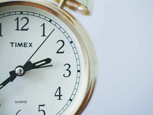 A close up of a clock with the hands showing the time as 2.35.