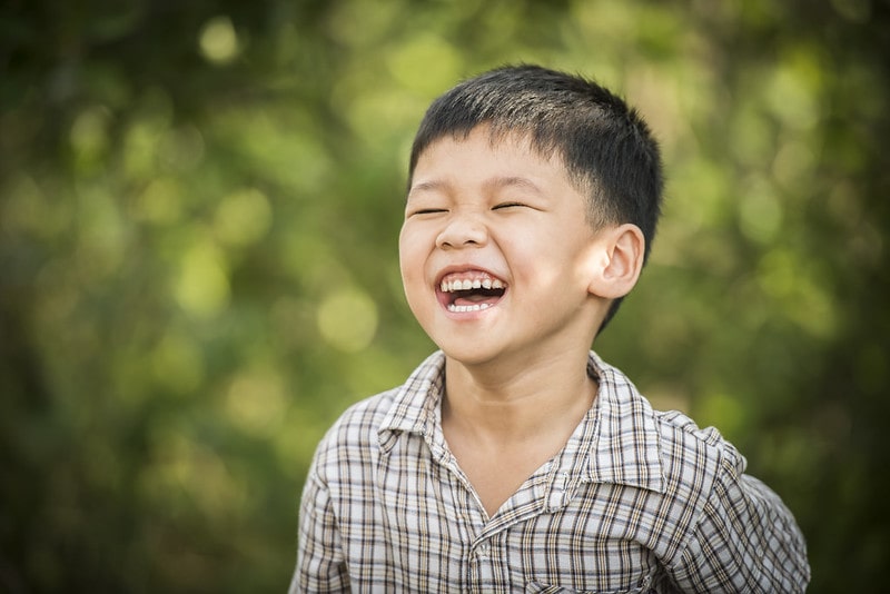 Boy outside laughing at Shrek jokes.