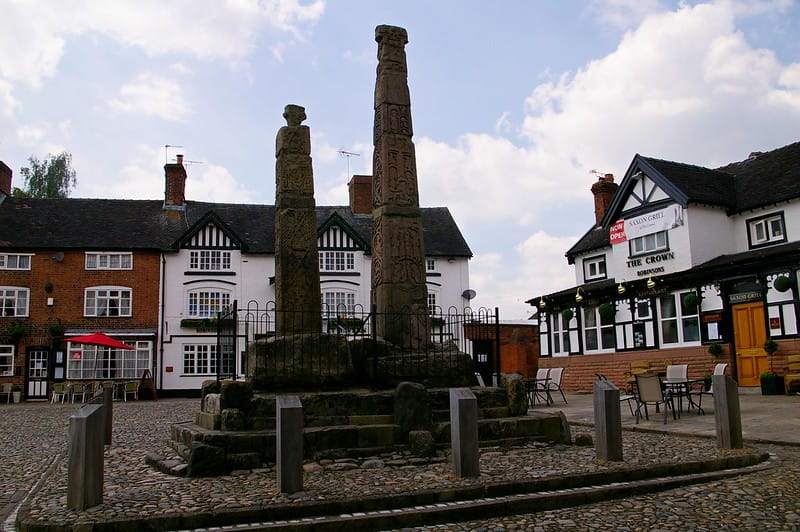 Town square in England with a pub in the corner and an Anglo-Saxon statue in the centre.