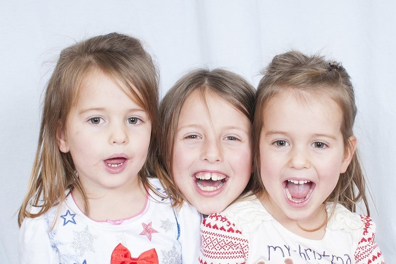 Three sisters happy and laughing together at corny jokes.