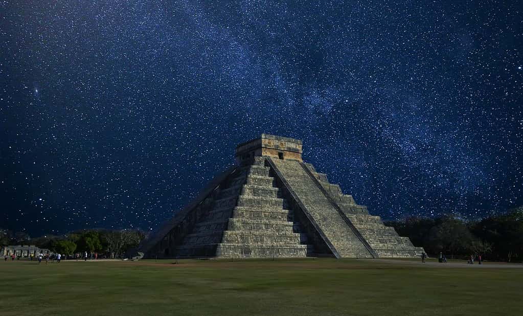 Chichen Itza at night with an amazing star-filled sky behind.