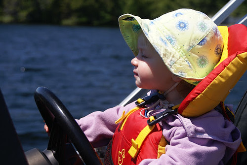 Baby sitting in a boat in a Salus Bijoux Baby Vest.