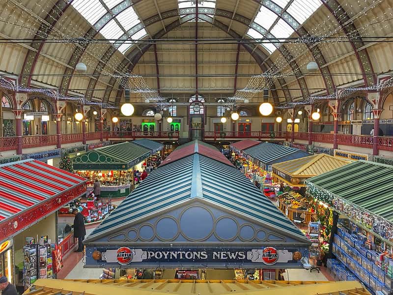 Inside Derby market at Christmas time with fairy light decorating all the stalls.