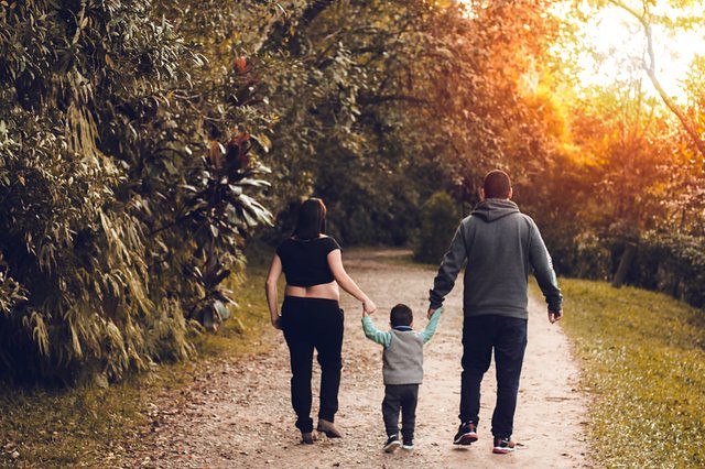 Mum and dad walking their toddler in the park in Maidstone.