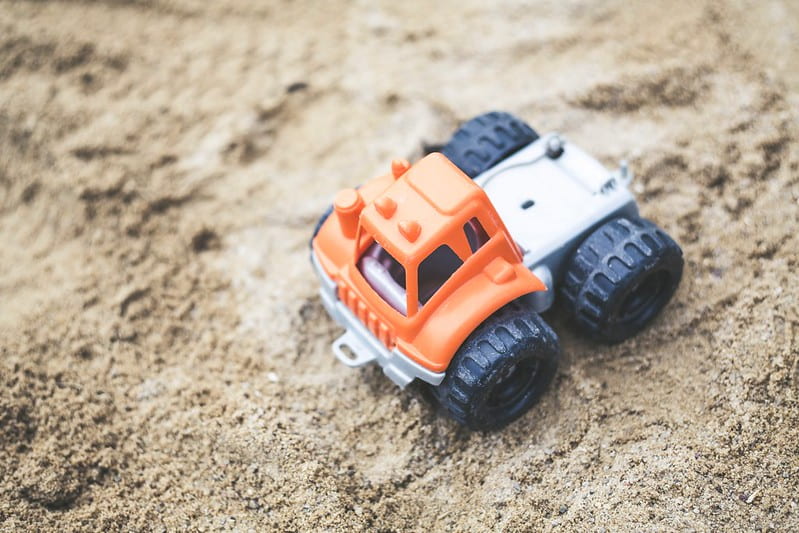 An orange toy digger in the sand in Hull.