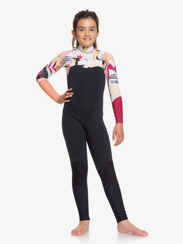 A young girl modelling the 3/2mm POP Surf Wetsuit, with fun patterns.