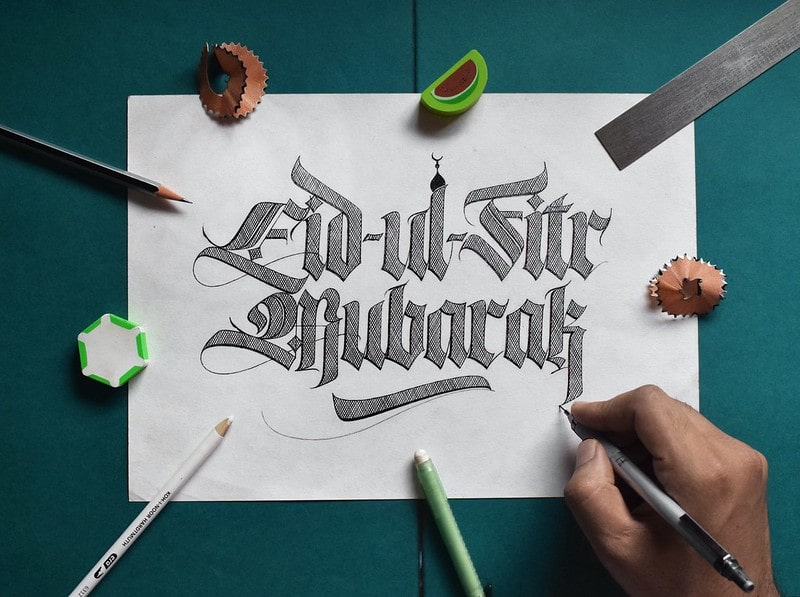 Happy Eid sign written on paper in caligraphy.