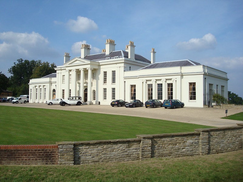 A front view of the Hylands Estate park house, a cream exterior with columns outside the front door.