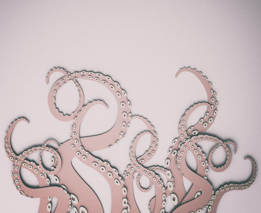 Pink card cut-out of octopus tentacles against a pink wall background.