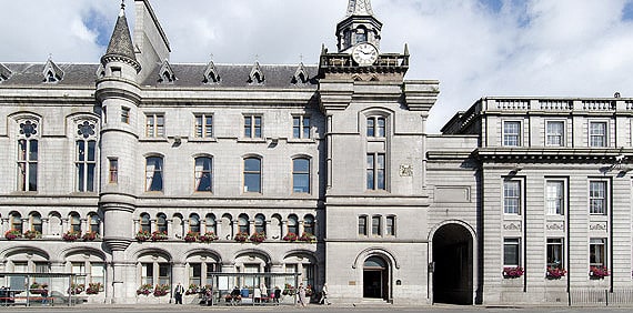 The front facade of the grey stone Tolbooth Museum building.