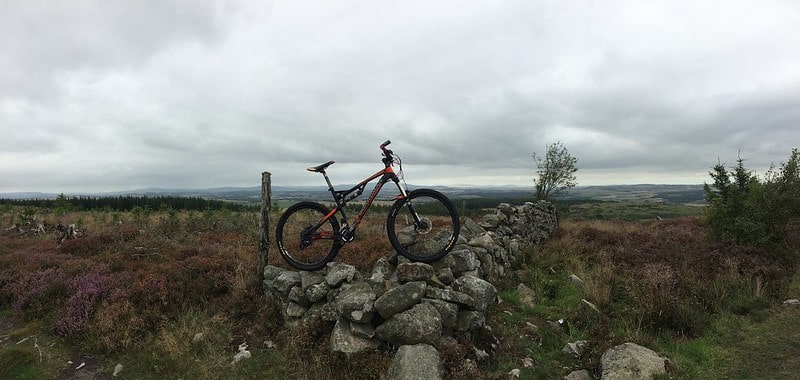 A bike on a rock wall in the countryside at Kirkhill Forest.