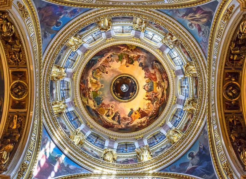 Beautiful painted ceiling of a church dome with gold borders around the arches.