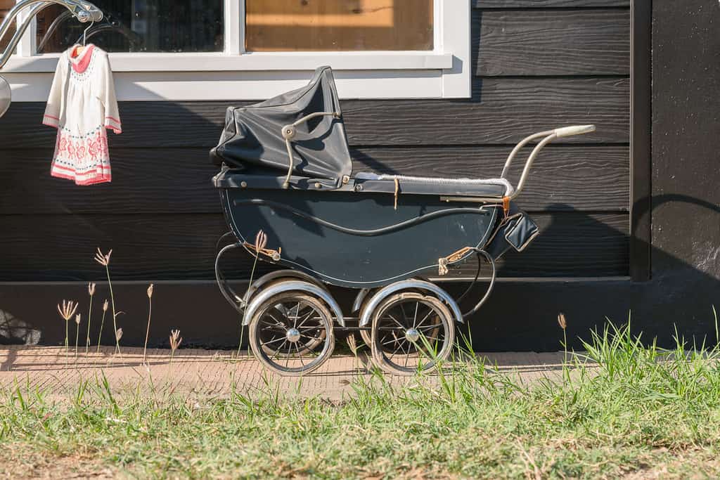 Old-fashioned Victorian stroller left outside a house.