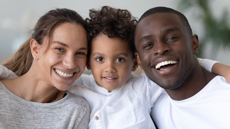 Parents smiling with their son, their face all inline so we can see any resemblance.