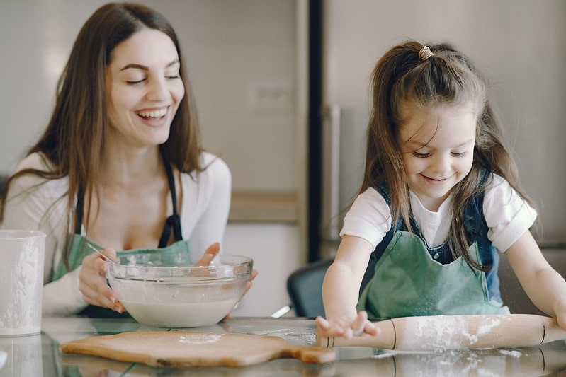 Happy mum and daughter in the kitchen baking a cake.