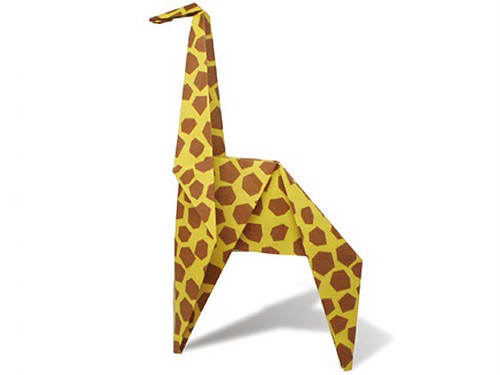 An origami giraffe made from a patterned piece of yellow paper.