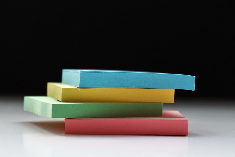 A pile of four different coloured pads of origami paper.
