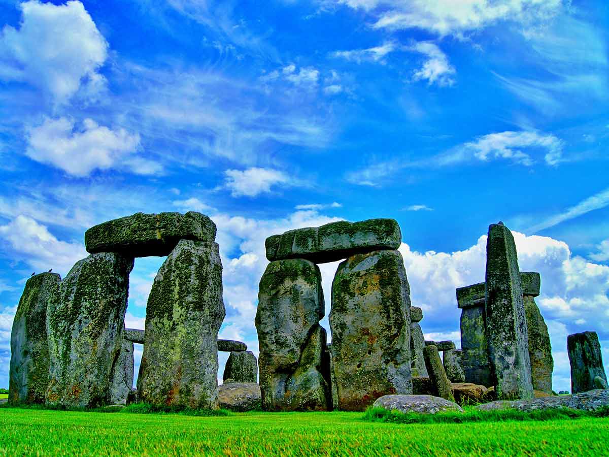Stonehenge on a sunny day with blue skies behind.