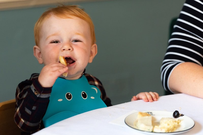 Young boy happily eating his food at afternoon tea.
