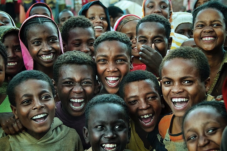 Crowd of young people and children laughing.
