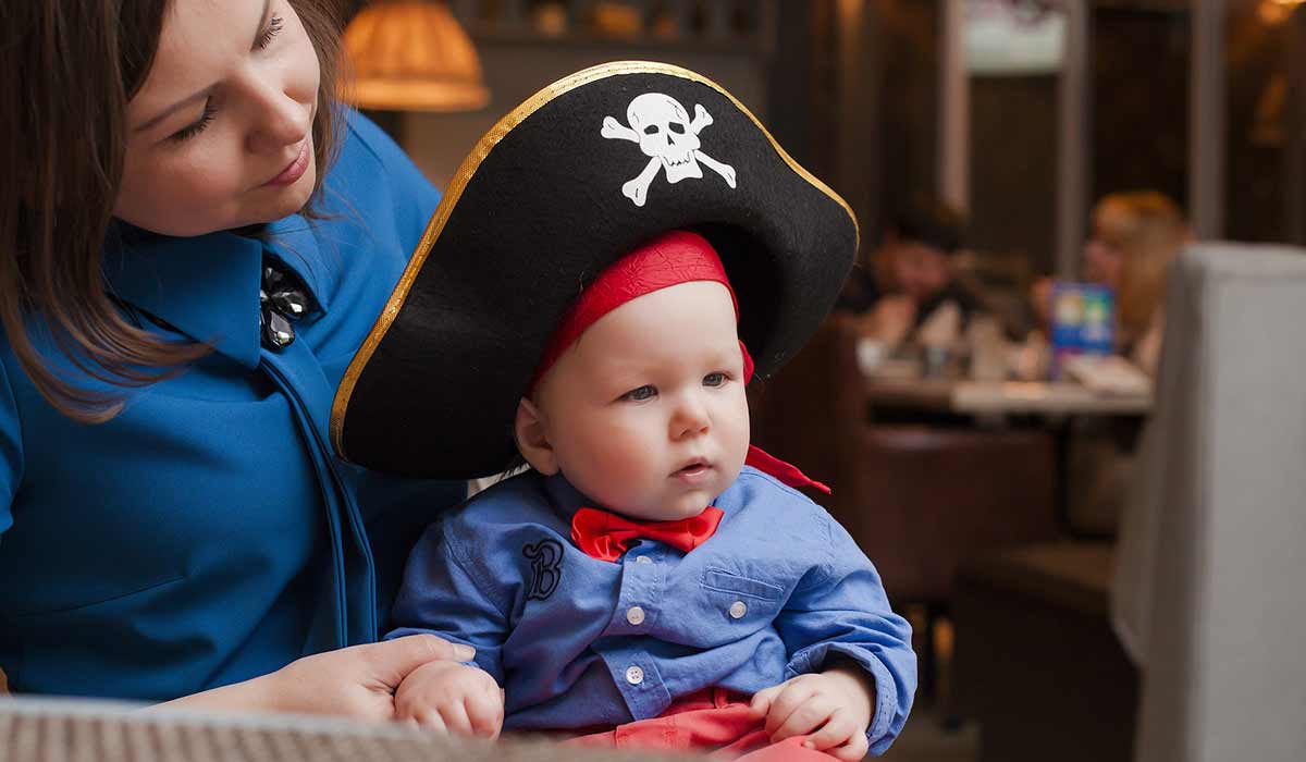 Mum holding baby son who is dressed as a pirate.