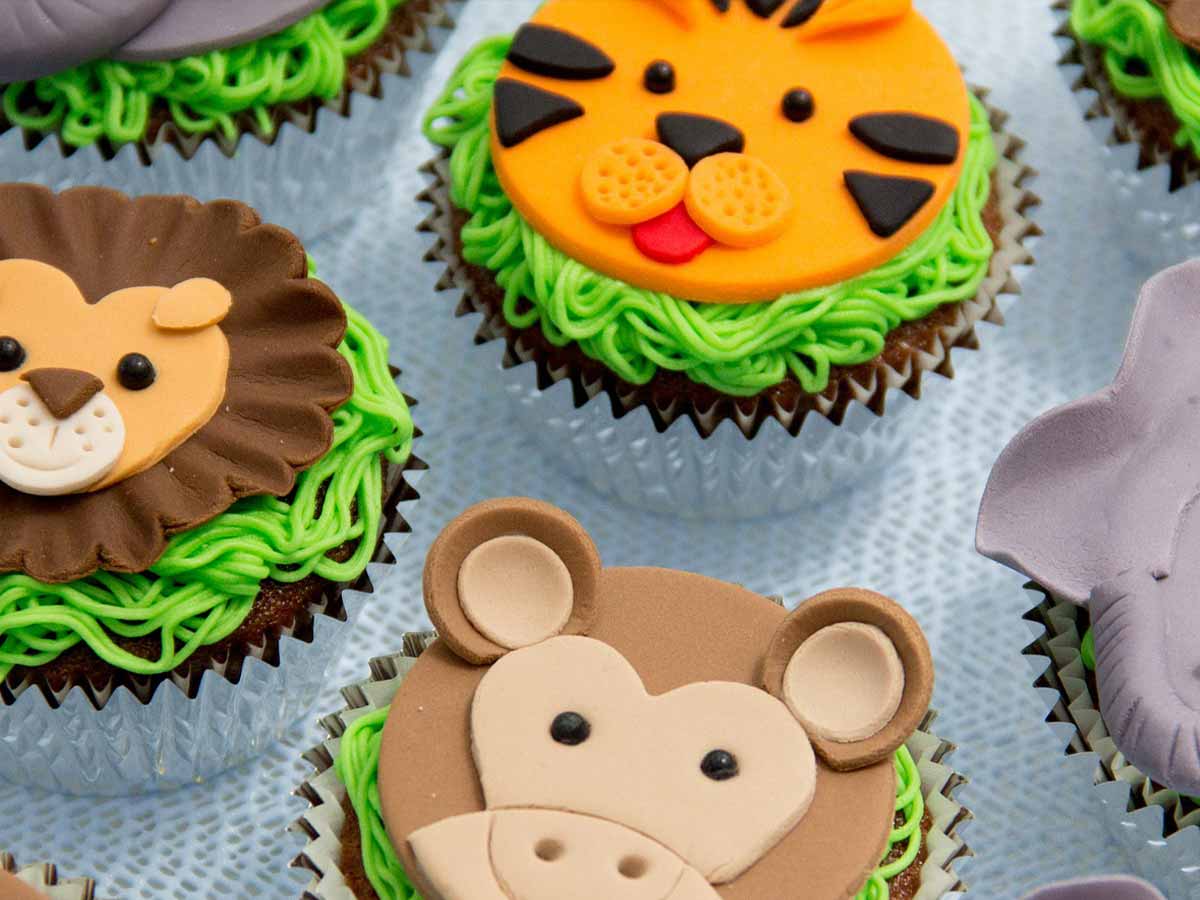 Jungle animal themed cupcakes, one with an icing tiger face on it.