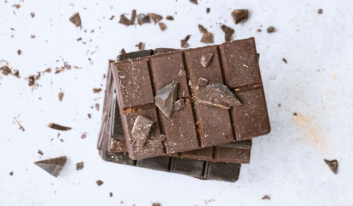 Stack of raw chocolate with shavings and crumbs all around it.