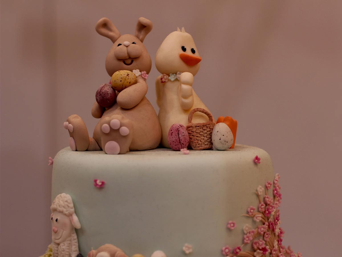 Easter cake with a fondant icing rabbit and chick sat on the top.
