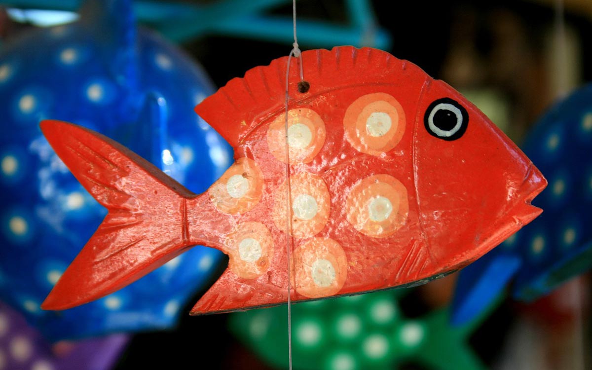 Red paper mache fish hanging from a string.