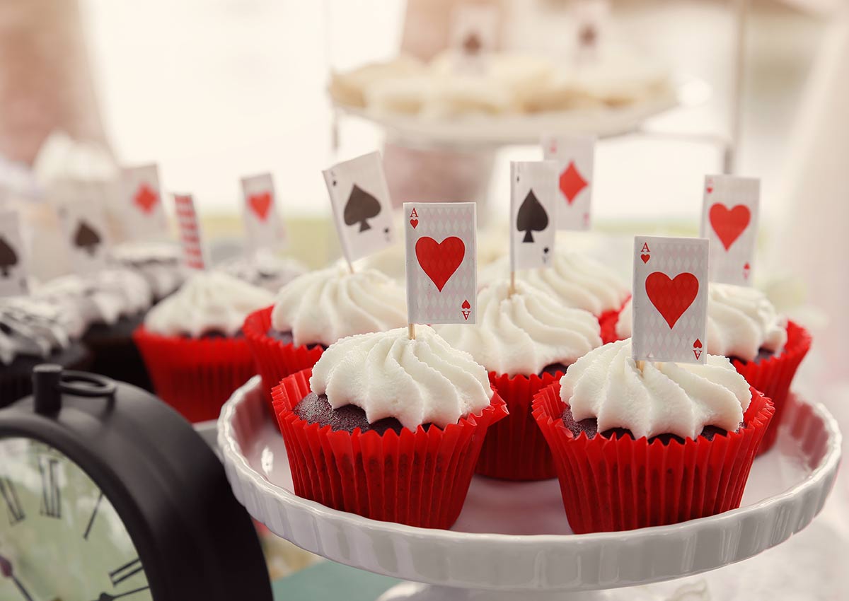 Cupcakes in red cases with decorations inspired by playing cards.