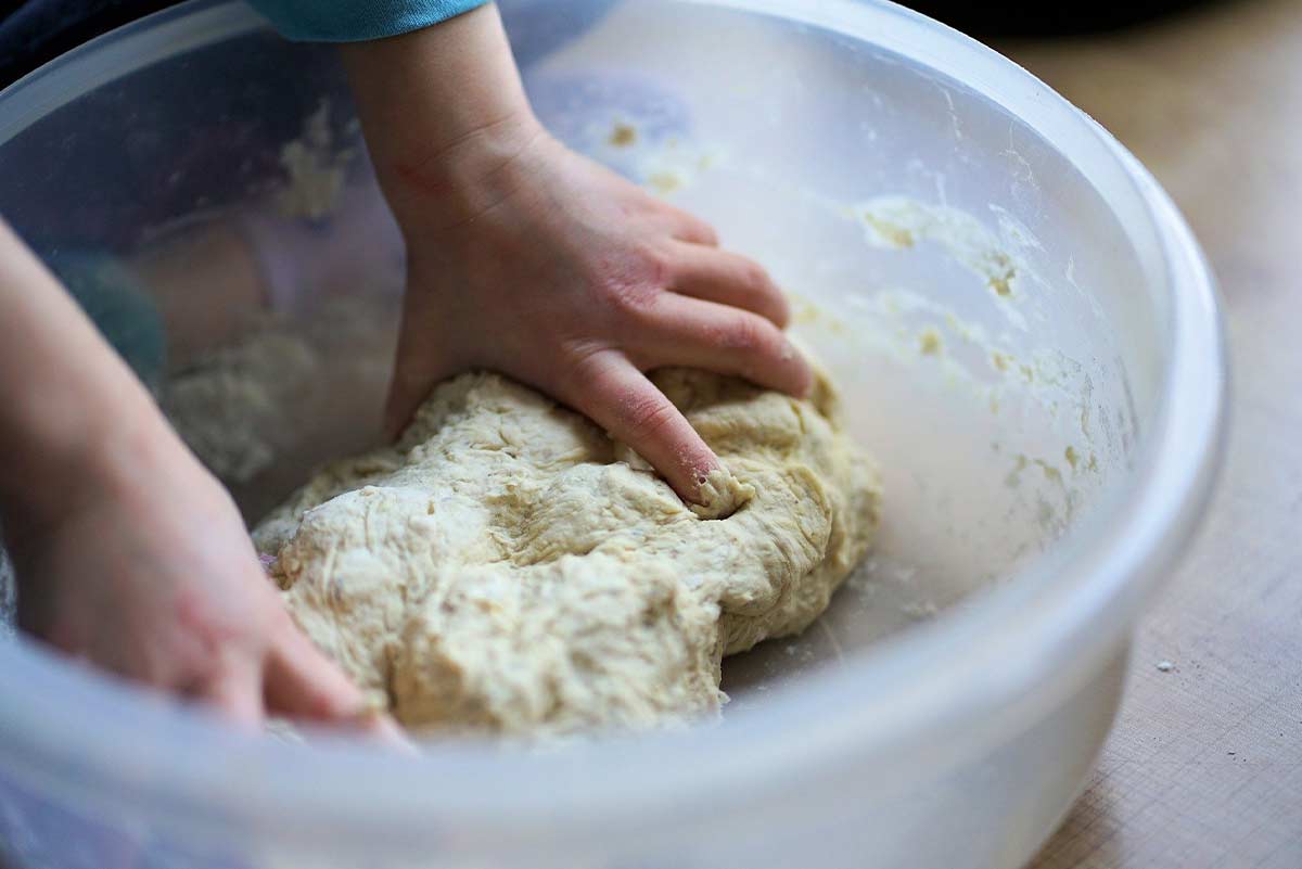 Close up of a child kneading dough.