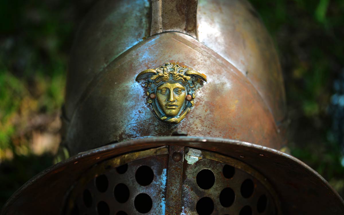 A Roman gladiator's metal helmet with a crest on the front.