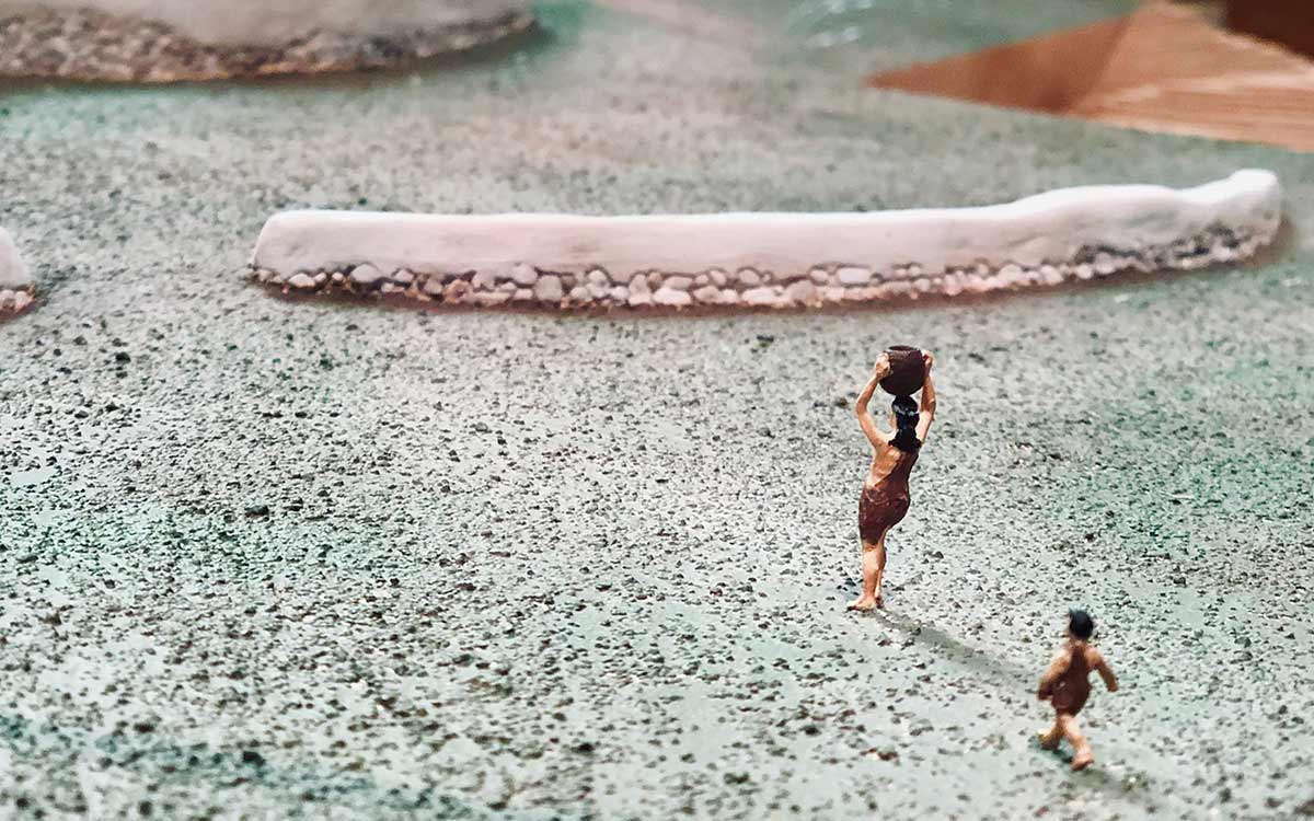 Little figurines of Stone Age people carrying tools.