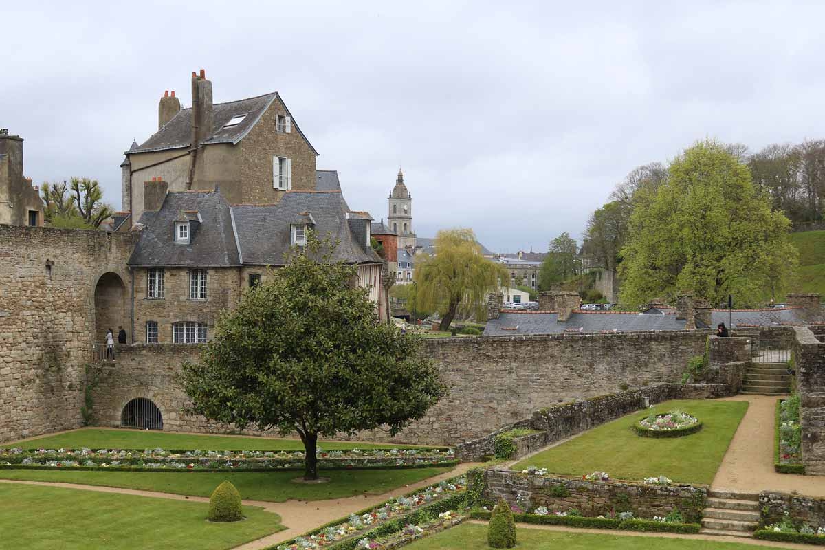 View of a Breton chateau and its gardens on a cloudy day in Brittany.