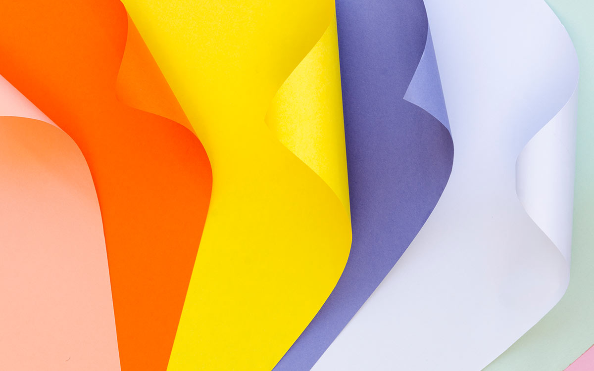 Sheets of different coloured paper for making easy origami tigers.