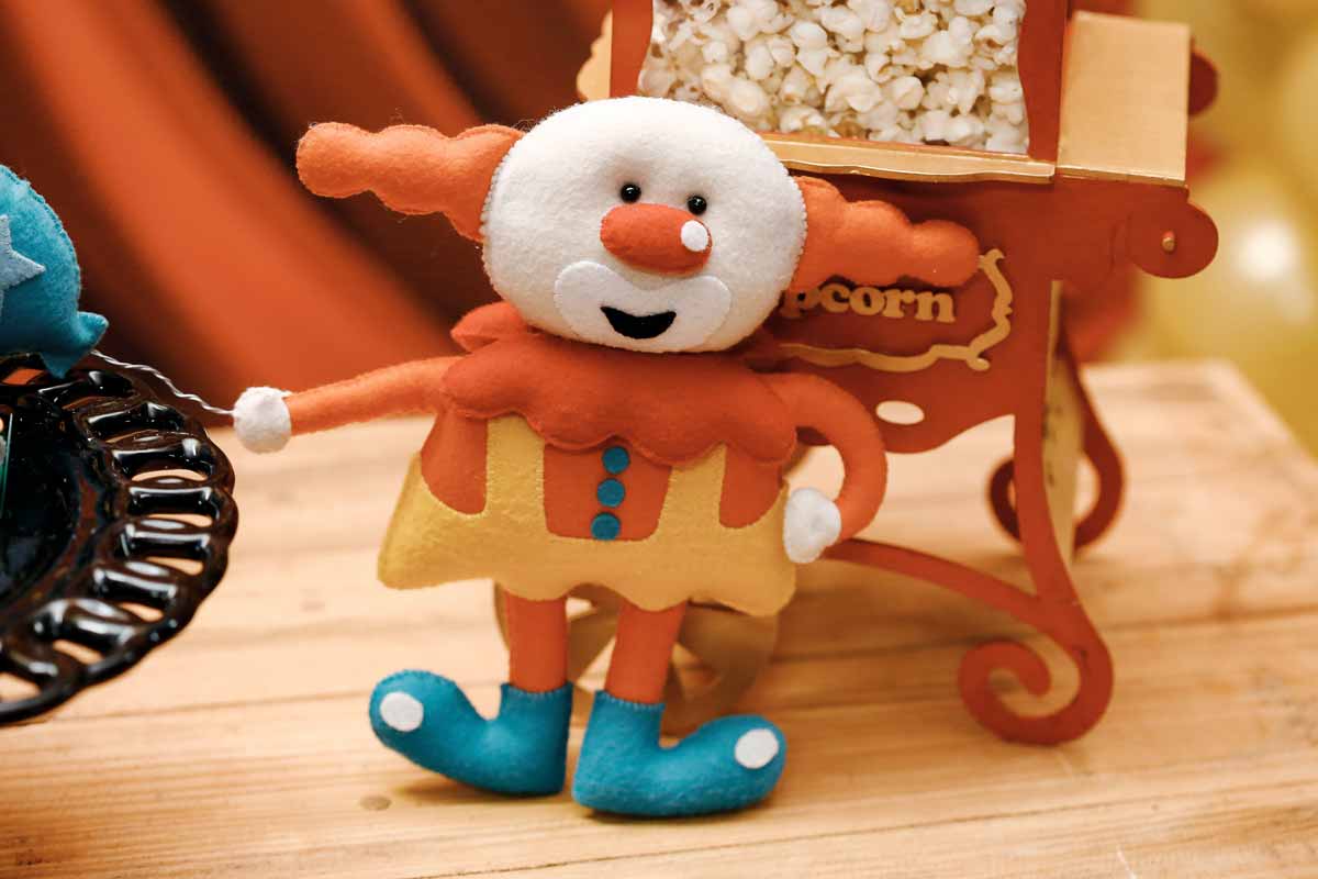 An image of a soft toy clown with red hair and a big red nose.