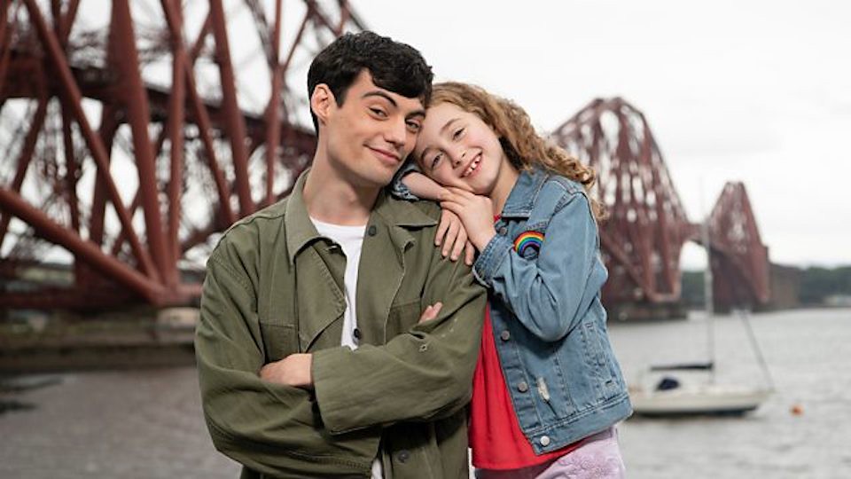 Molly and Mack from CBeebies standing together, Molly resting on Mack's shoulder.