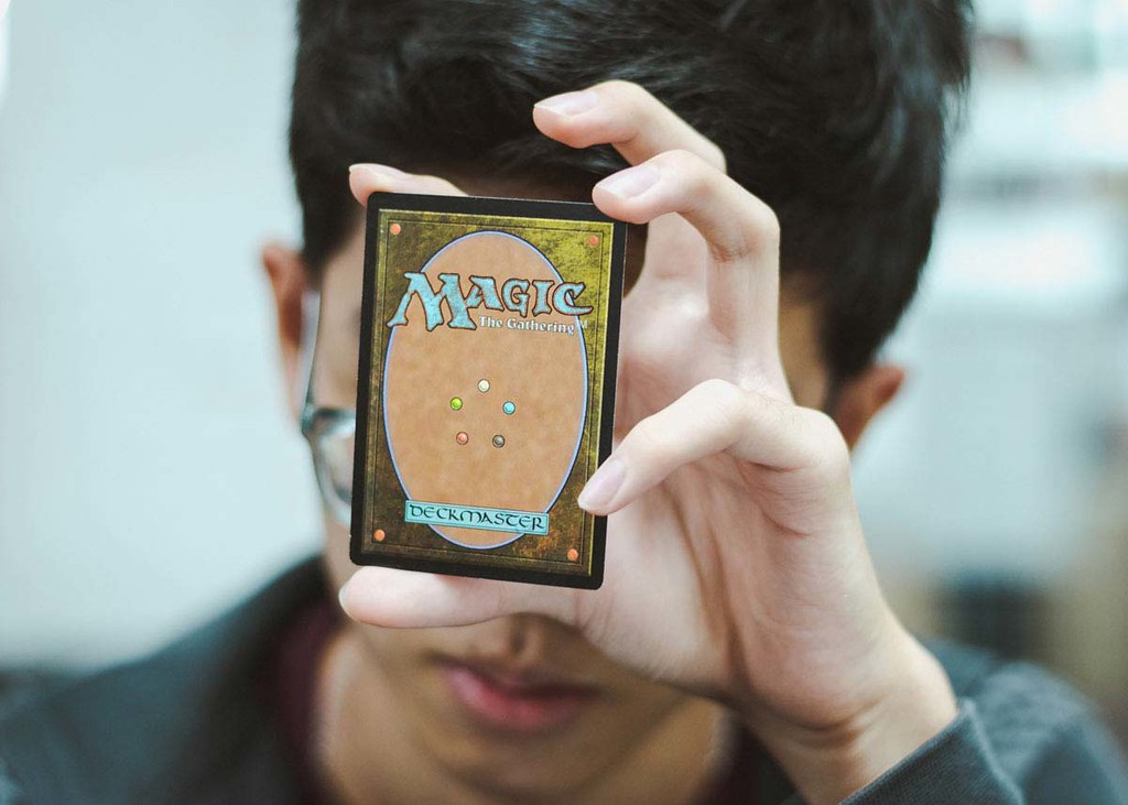 A little boy is holding a small book of magic puns up to the camera.