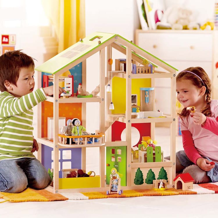 Little boy and girl playing with the Hape All Season House.