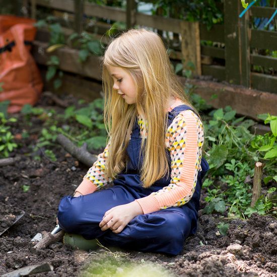Young girl outdoors wearing Muddy Puddles Originals Bib And Brace.