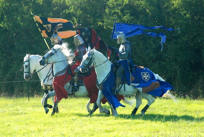 Medieval soldiers carrying the flags of the royal kingdoms.
