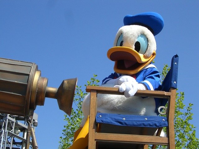 Disney's Donald Duck sitting in a director's chair.