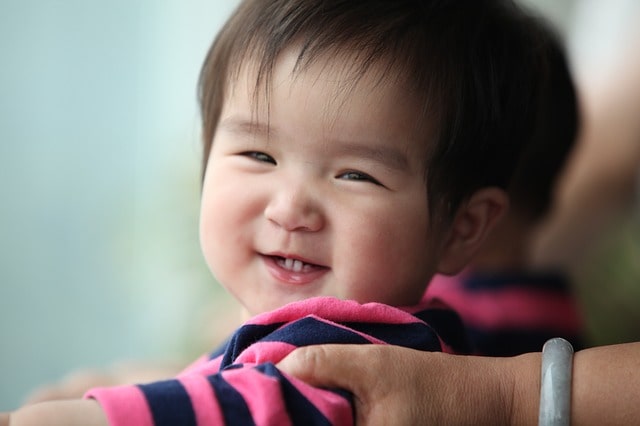 Adorable Thai-Chinese baby happily flashing his bright smile.