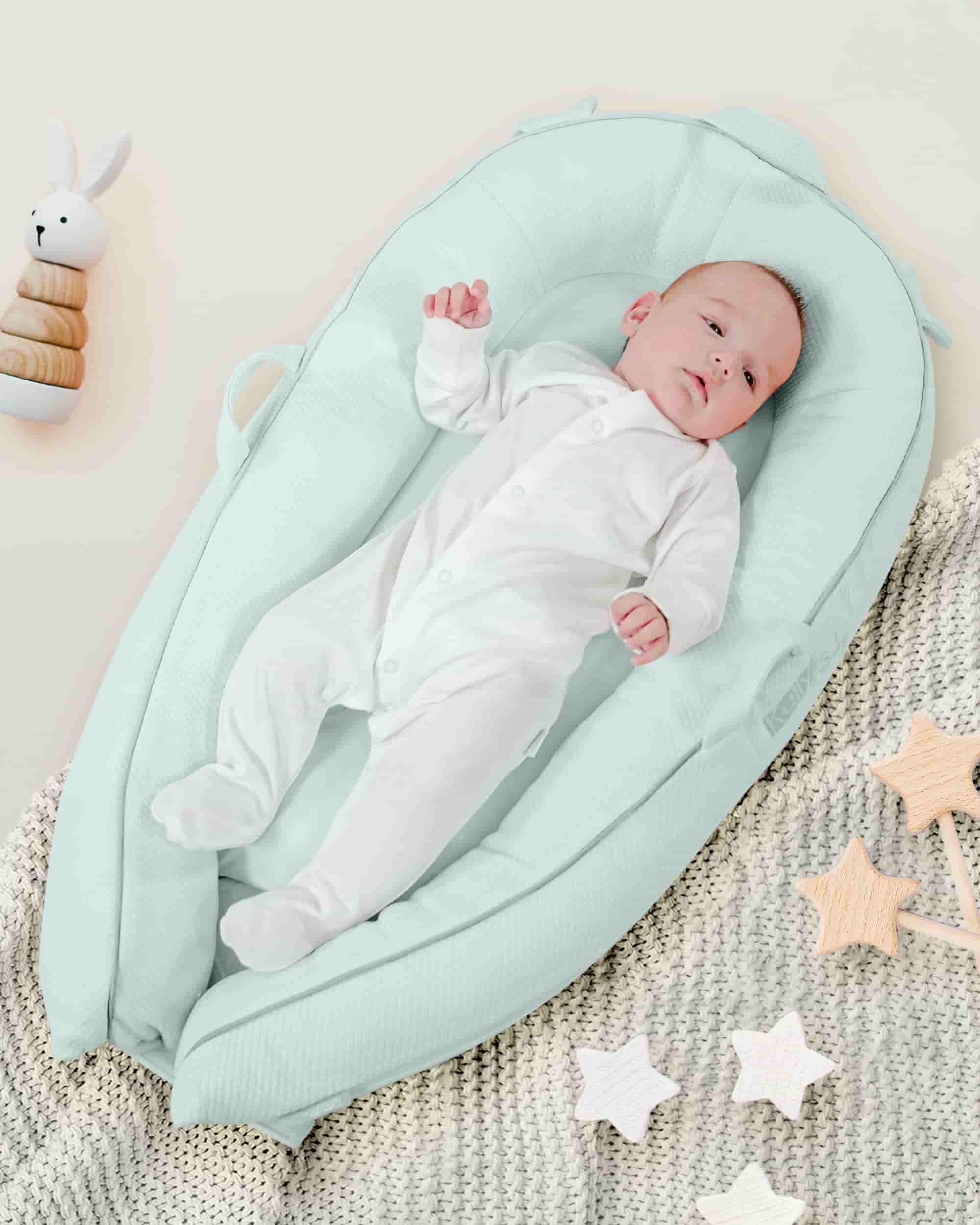 Adorable baby lying down in the smooth blue pod.
