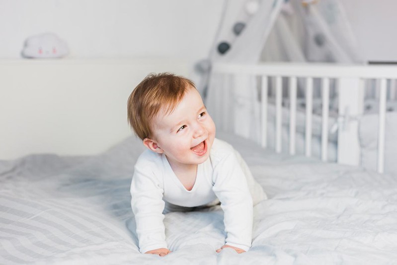 Baby boy gleefully smiling.