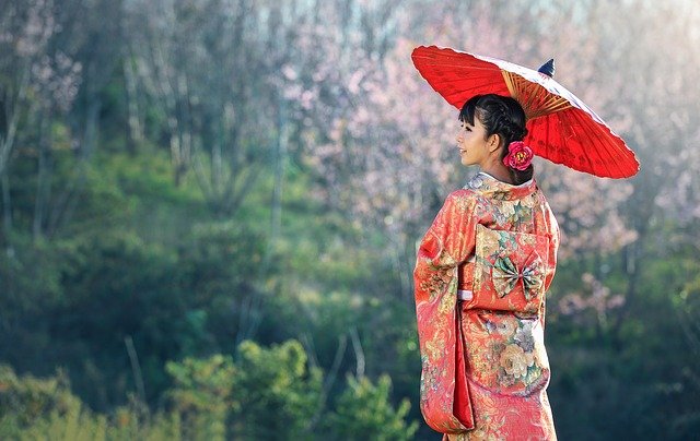 Beautiful Japanese maiden wearing a red kimono.