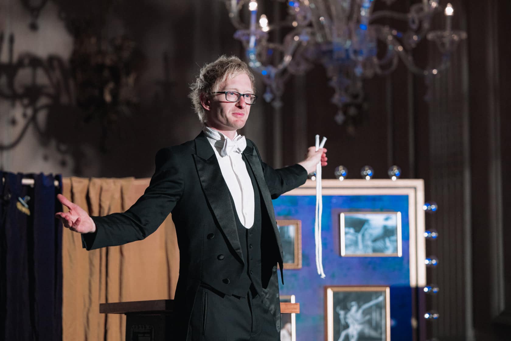 A magician holding two pieces of string during a magic trick.