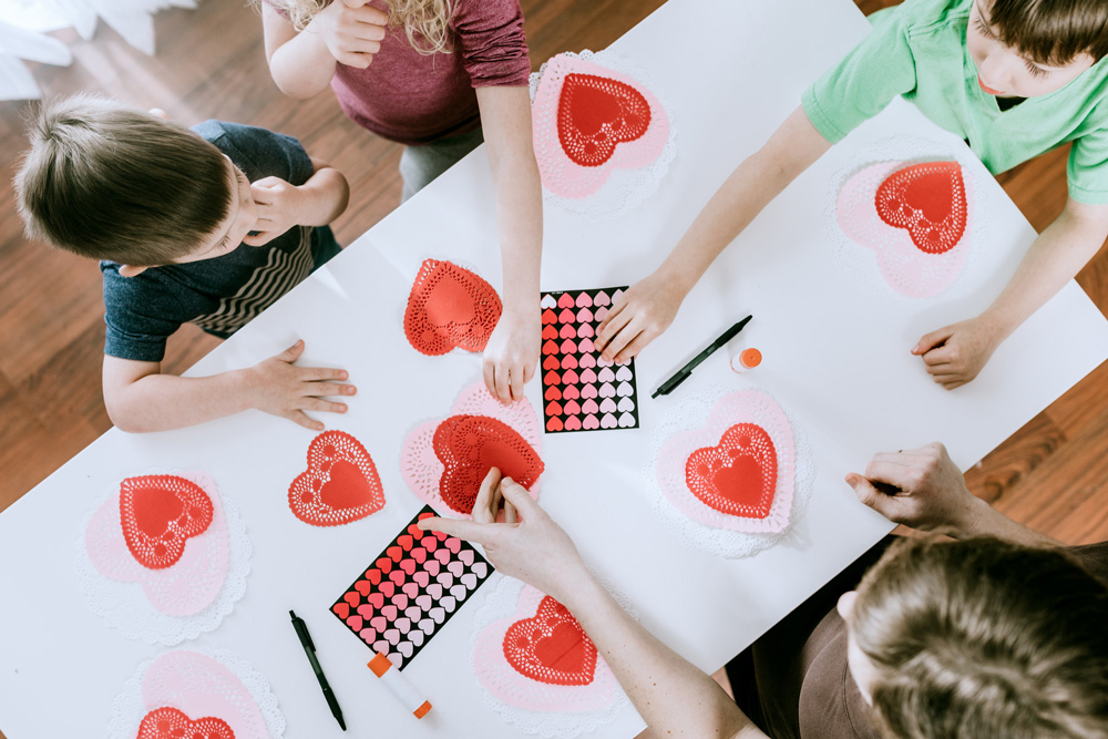 Children making cards with love hearts.