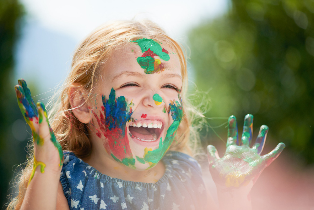 A little girl covered in paint.
